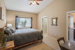 Master bedroom with queen bed, vaulted ceilings, desk, and ensuite bathroom
